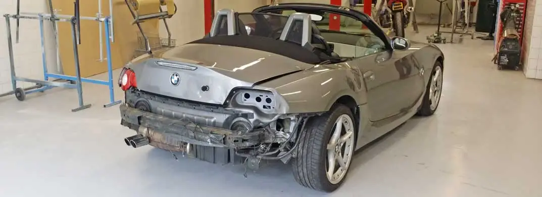 Grijze BMW Z4 met schade aan de achterzijde in de werkplaats van Danny Autoschade