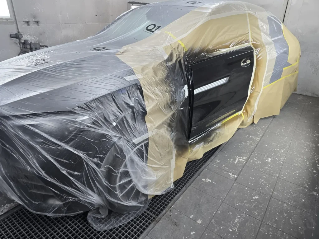 Auto zorgvuldig afgeplakt met folie en tape in de spuitcabine van Danny Autoschade, klaar om te spuiten