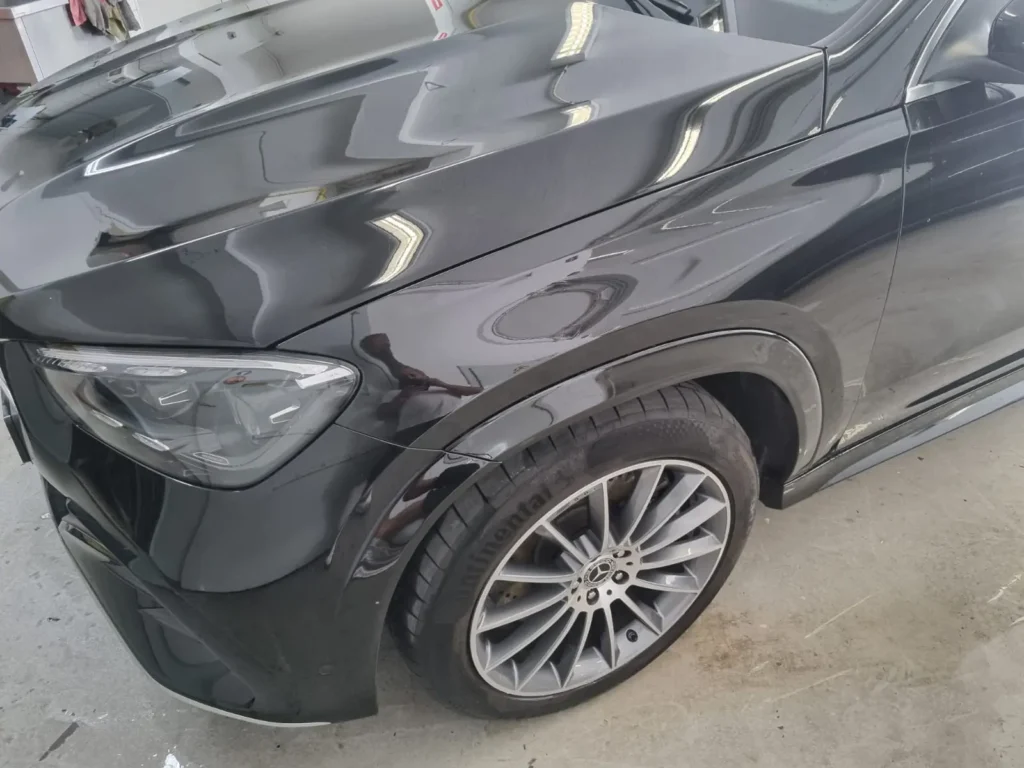 Zwarte Mercedes GLE Coupe met deukschade in het voorscherm, voor het herstel